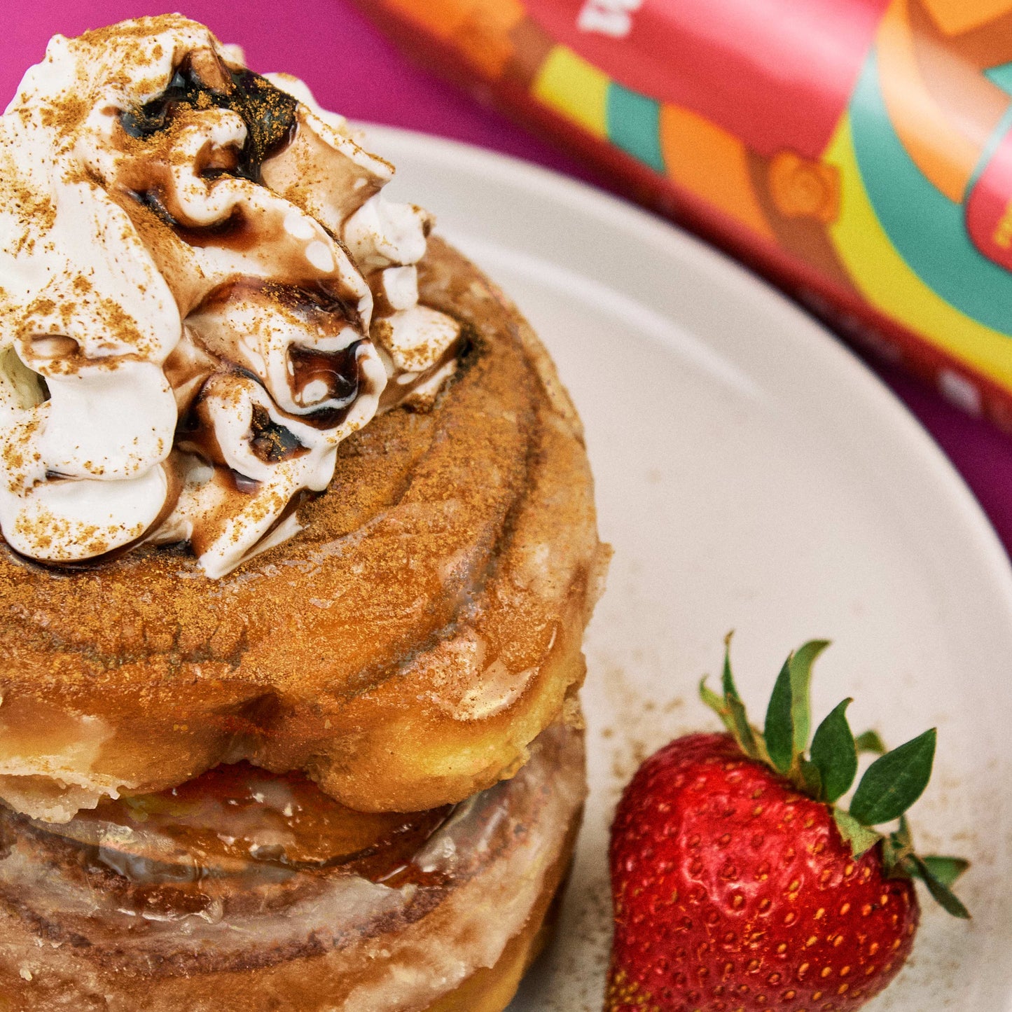 
                  
                    Stack of pancakes with whipped cream and a strawberry on a plate, with a can of WhippaPro in the background.
                  
                